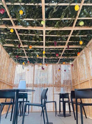 Schlemmen in der Sukka: Laubhütte mit Stühlen und Tischen.