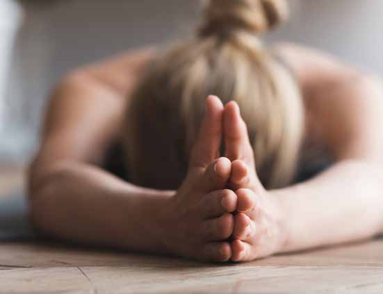 Yoga im Museum: Frau liegt auf dem Bauch mit geschlossenen Händen.